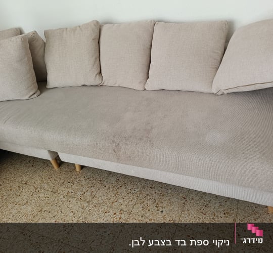 כתם על ספה בהירה עם כריות
